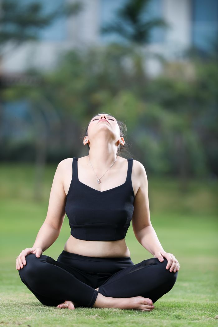 services-04 Adult woman meditating in a peaceful outdoor setting. Focused on relaxation and mindfulness.